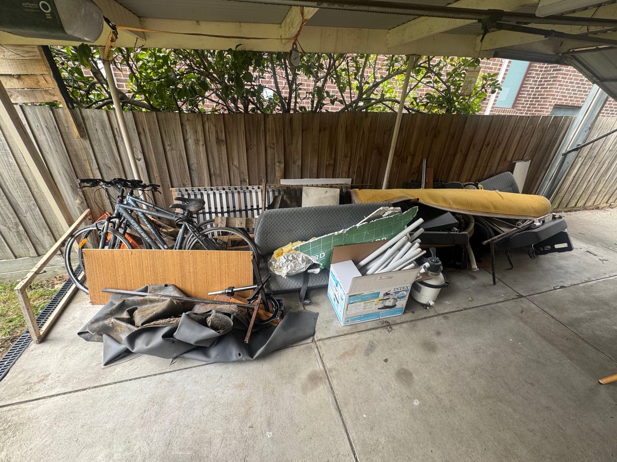 Carport with a table and household junk before rubbish removal in Melbourne