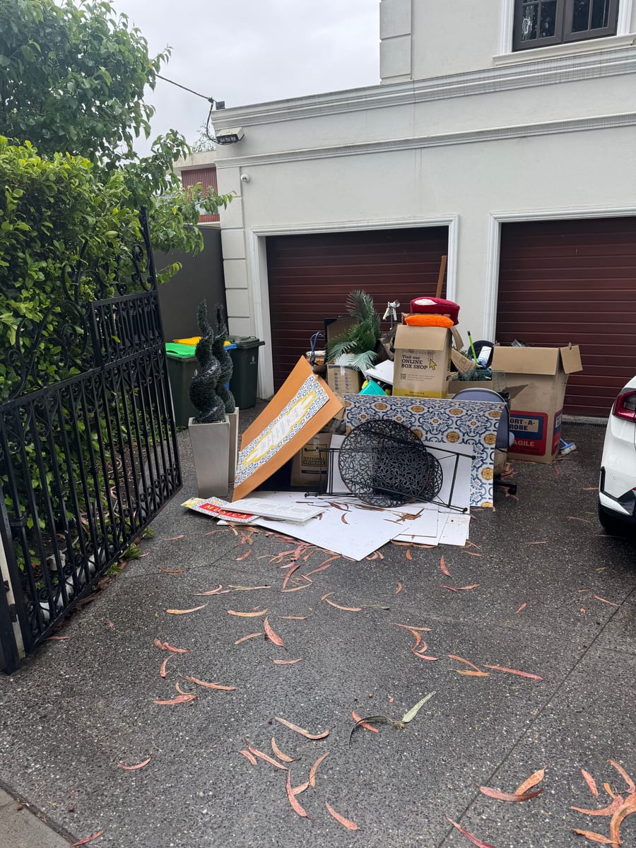 Driveway in front of garages scattered with rubbish before removal in Melbourne