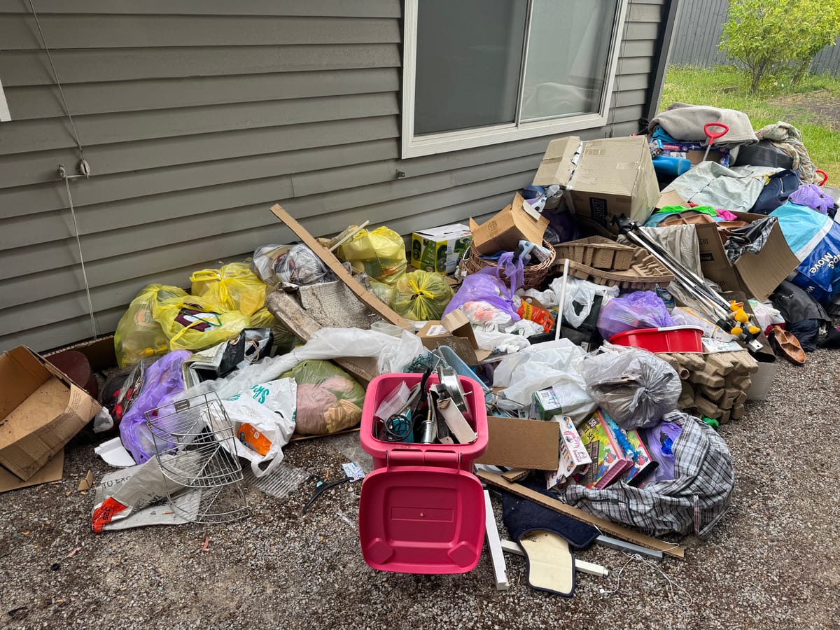Large pile of household goods and bags on a front lawn before rubbish removal in Melbourne