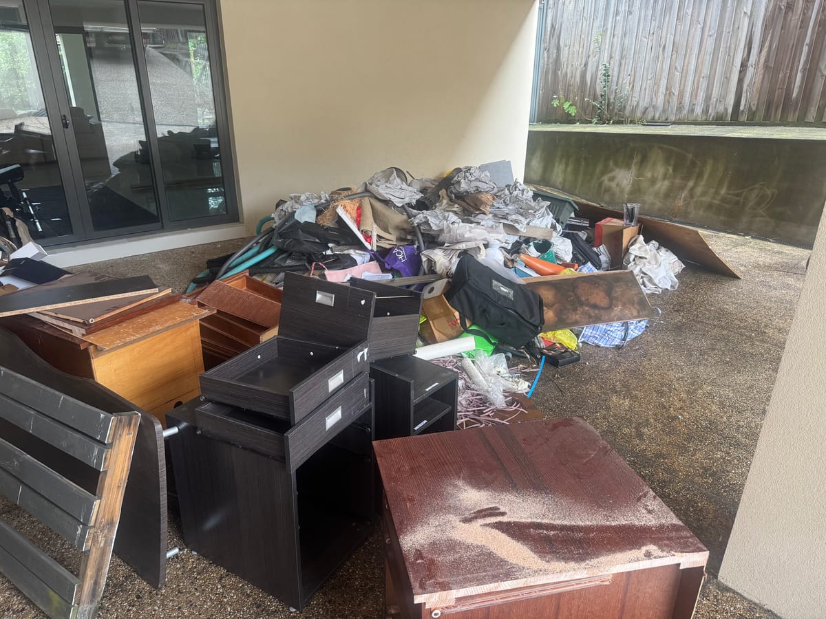 Carpeted room full of furniture and household goods before a real estate cleanout in Melbourne
