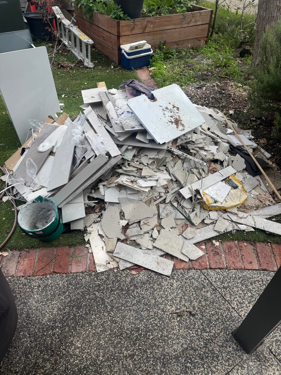Pile of renovation waste, timber and plasterboard on a lawn before removal in Melbourne