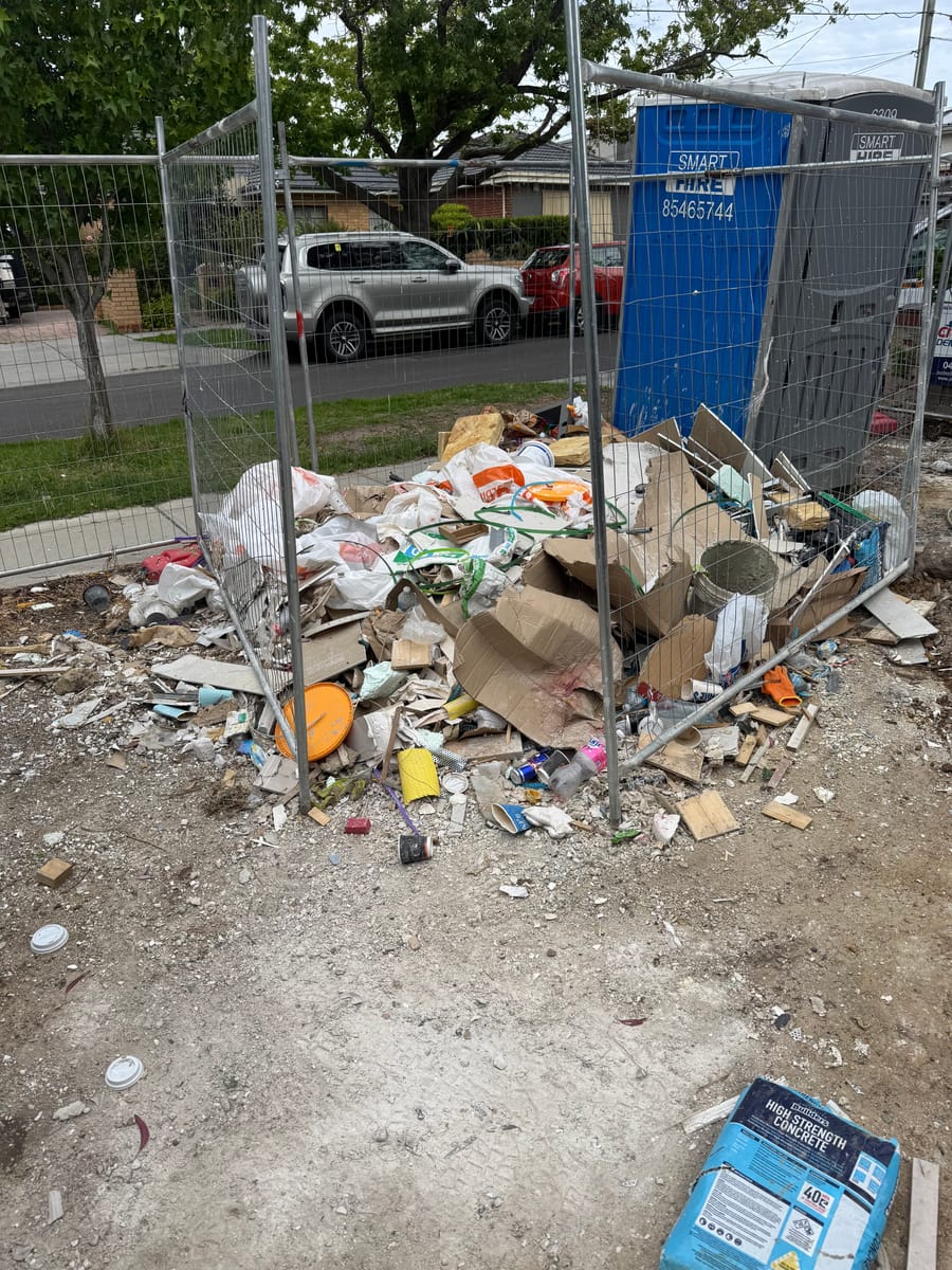 Front yard with renovation rubble and bins before waste removal in Melbourne